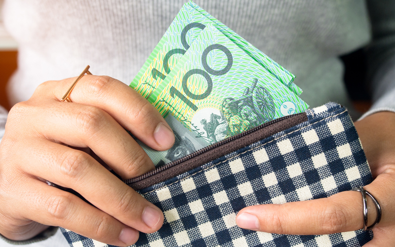 Australian money being put into wallet